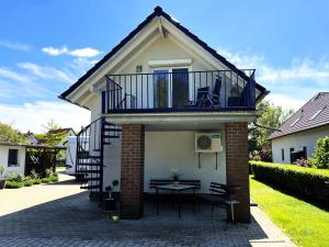 a house with a balcony and a table on a patio at Gästehaus Seenland in Lauta