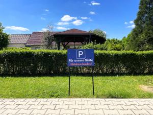 a sign in the grass in front of a house at Gästehaus Seenland in Lauta