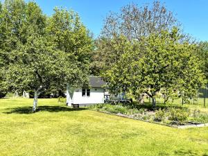 a white house in a field with trees at Gästehaus Seenland in Lauta
