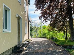 an empty street next to a building with a tree at GER-Haus in Waischenfeld