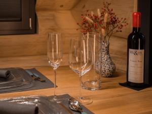 a table with three wine glasses and a bottle of wine at Mein Refugium Luxury Tiny House in Unteriberg +14 photos