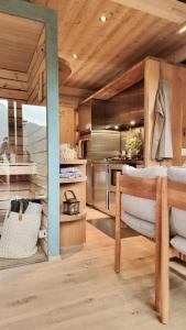 a kitchen with wooden ceilings and a wooden table and chairs at Mein Refugium Luxury Tiny House in Unteriberg