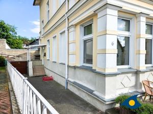 a house with a white fence on the side of it at Villa Utpatel Whg 01 in Ahlbeck