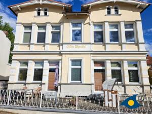 a building with chairs in front of it at Villa Utpatel Whg 01 in Ahlbeck