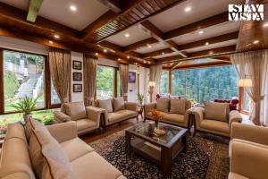 a living room with couches and a table at Simla Manor by VEO - Part of StayVista in Shimla