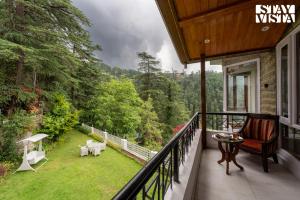 a balcony with a view of a yard at Simla Manor by VEO - Part of StayVista in Shimla