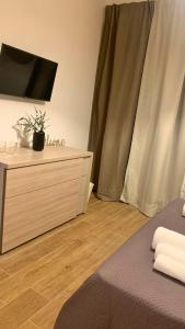 a bedroom with a bed and a dresser with a television at Masseria della Fontana Vecchia in San Cipriano Picentino