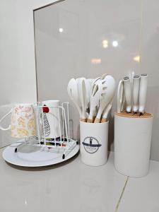 a group of utensils sitting on a counter at Raed Homestay by ASH in Biñan +41 photos
