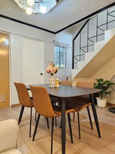 a dining room with a black table and chairs at Raed Homestay by ASH in Biñan