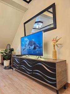 a tv on a dresser in a living room with a mirror at Raed Homestay by ASH in Biñan