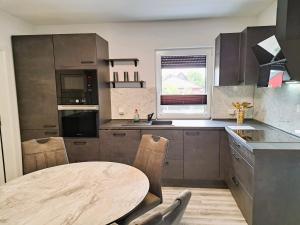 a kitchen with a wooden table and a round table at Ferienhaus "Laila" ID 16019-2 in Möllenhagen