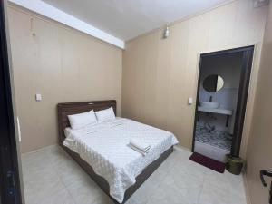 a bedroom with a bed and a mirror in it at Thanh Thao Hostel - HaGiang Loop Tour in Làng Lap