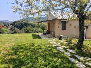 a house with a tree and a grass yard at Αγρόκτημα Βερνικο in Paráplati