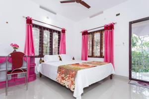 ein Schlafzimmer mit rosa Vorhängen und einem Bett und einem Fenster in der Unterkunft Mount Spring Valley Homestay in Thekkady