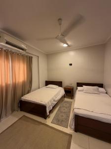 a bedroom with two beds and a window at The Nile Paradise in Al Aqālitah