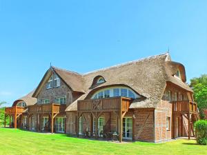 a large brick house with a gambrel roof at Haus an der Düne Whg 10 in Lobbe