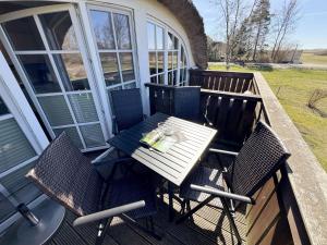 a table and chairs on the porch of a house at Haus an der Düne Whg 10 in Lobbe
