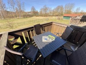 a table and chairs on a deck with a view of a field at Haus an der Düne Whg 10 in Lobbe +12 photos