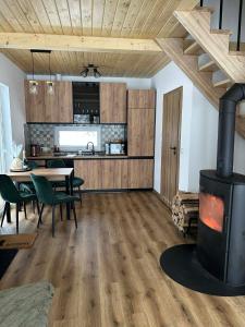 a kitchen and dining room with a stove in a room at OAK House domek z balią w Serskim Lesie in Las Dalny