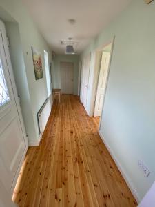 an empty hallway with wooden floors and white doors at Claddagh in Galway