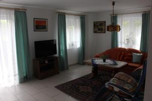 a living room with a couch and a tv at Ferienwohnung am Kittenbach in Utting am Ammersee