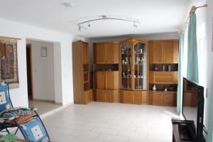 a living room with wooden cabinets and a tv at Ferienwohnung am Kittenbach in Utting am Ammersee