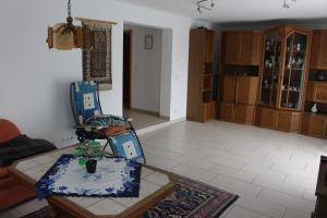 a living room with a chair and a table at Ferienwohnung am Kittenbach in Utting am Ammersee