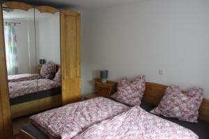 a bedroom with two beds and a mirror at Ferienwohnung am Kittenbach in Utting am Ammersee