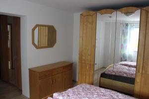 a bedroom with two beds and a dresser and a mirror at Ferienwohnung am Kittenbach in Utting am Ammersee +17 photos