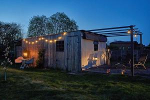 a shed with lights and a table in a yard at Reetdachhaus De Ole Kaat in Niesgrau
