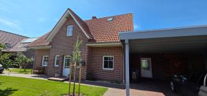 a brick house with a car parked in front of it at Nr 200 - Ferienwohnung Süderriff in Neuharlingersiel