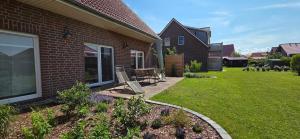 a yard with a patio with a table and chairs at Nr 200 - Ferienwohnung Süderriff in Neuharlingersiel