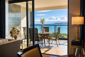 a dining room with a view of the ocean at The Elysium Prațumnak Pattaya - By SHG in Pattaya South