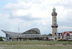 a lighthouse in front of a building with a building at Warnemünde Fischer`s Hus 10139 in Rostock