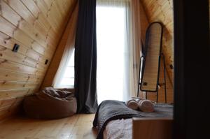 a bedroom with a bed and a window with a surfboard at MM's Cottage in Kazbegi