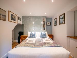 a bedroom with a large bed with blue pillows at Stylish Reverse-Level Retreat for couples in Totnes