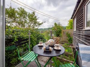 a small table and chairs on a patio with a tea set at Stylish Reverse-Level Retreat for couples in Totnes