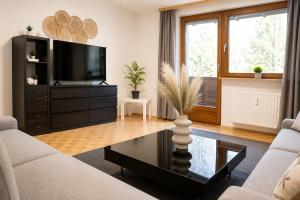 a living room with a tv and a table at Appartement zur Gemütlichkeit - Ski Juwel im Alpbachtal in Wörgl