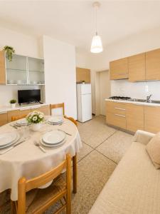 a living room with a table and a kitchen at RESIDENCE PACE - Agenzia Cocal in Caorle +31 photos