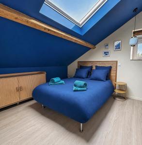 a blue bedroom with a bed with blue pillows at Élégant T3 moderne et central, parking inclus in Montargis