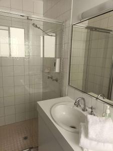 a white bathroom with a sink and a mirror at Motel in Nambour in Nambour +2 photos
