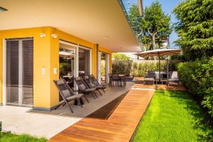 a patio with chairs and a table and umbrella at Mirabello Private Pool Apartment in Bardolino