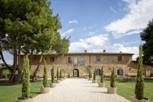 un domaine avec des arbres devant un bâtiment dans l'établissement Wine Resort Conti di San Bonifacio, à Montemassi