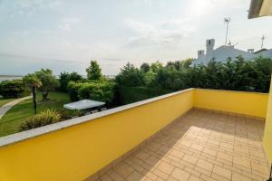 a yellow wall with a bench on a balcony at Scirocco in Isola Albarella