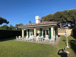 a small house with white chairs and a table at Adria in Isola Albarella