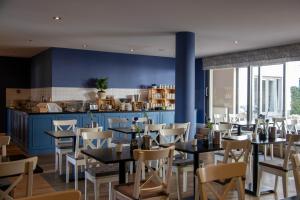 ein Restaurant mit blauen Wänden, Tischen und Stühlen in der Unterkunft Hotel Gulpenerland in Gulpen-Wittem