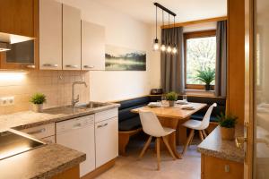 a kitchen with a table and a dining room at Appartement zur Gemütlichkeit - Ski Juwel im Alpbachtal in Wörgl