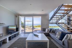 a living room with a couch and a tv and a table at Seascape in Plettenberg Bay