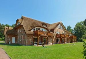 a large large house with a thatched roof at Haus an der Düne WE 05 in Lobbe