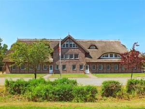 a large brick building with a flag in front of it at Haus an der Düne WE 05 in Lobbe